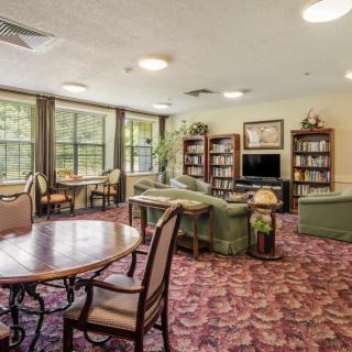 A cozy living area with bookshelves, seating, and bright lighting.