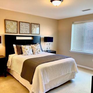 A cozy and well-decorated bedroom with a large bed, stylish lamps, and natural lighting.