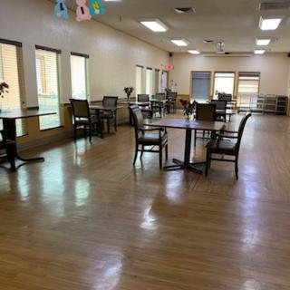 A spacious and well-lit dining area with tables and chairs arranged for use.