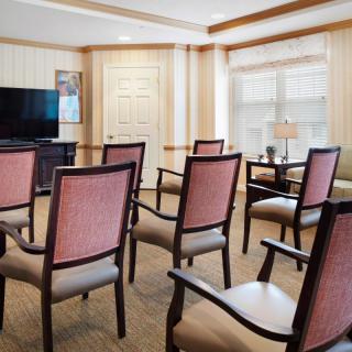A small meeting room setup with chairs facing a television.