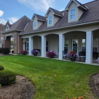 A beautifully landscaped house featuring a charming porch and vibrant flowers.