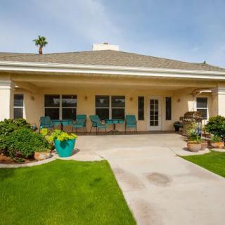 A cozy backyard patio with well-maintained lawn and outdoor seating.