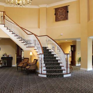 A grand staircase in an elegant hotel lobby with classic furnishings.