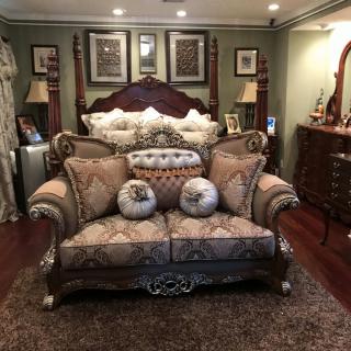 A luxurious bedroom with traditional furnishings, featuring a plush sofa and ornate decor.