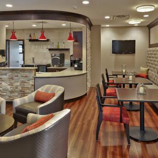 A modern cafe interior with cozy seating and wooden flooring.