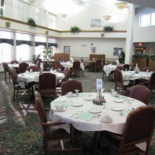 A well-lit restaurant dining area with neatly set tables and chairs.