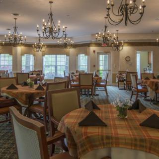 An elegant dining room with chandeliers and neatly set tables.