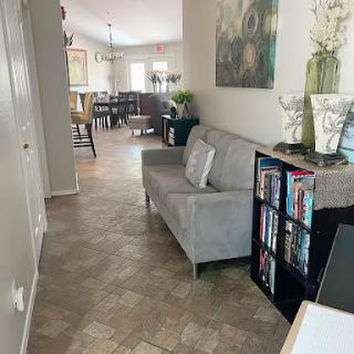 A cozy living room with a gray sofa and a bookshelf, creating an inviting atmosphere.