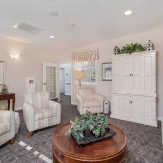 A cozy living room with comfortable chairs, a wooden coffee table, and elegant decor.