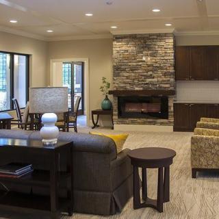 A modern living room with a stone fireplace and comfortable seating.