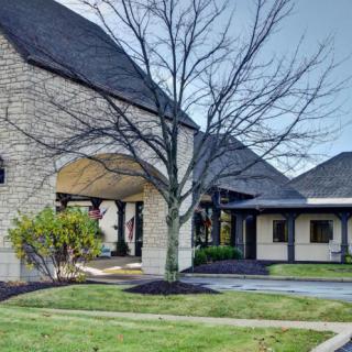 A modern building with stone facade and landscaped surroundings.