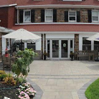 A charming building with an inviting outdoor area and vibrant flowers.
