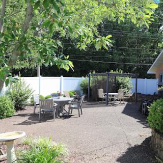 A serene outdoor patio area surrounded by greenery, perfect for relaxation.