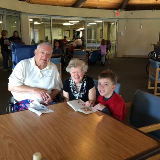 A family enjoying reading together at a library table.