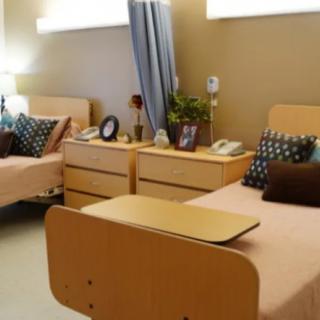 A hospital room with twin beds and medical equipment.