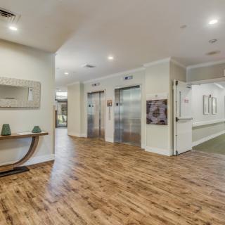 Modern lobby interior with wood flooring and elevators.