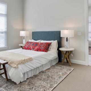 A cozy bedroom with a stylish bed, decorative pillows, and bedside lamps.