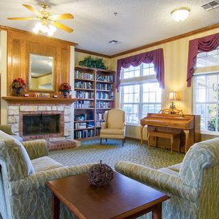 A cozy living room featuring a fireplace, bookshelves, and comfortable seating.