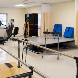 A physical therapy room equipped with exercise and rehabilitation equipment.