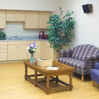 A cozy waiting area featuring comfortable seating, a wooden coffee table, and decorative plants.