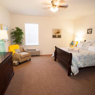 A cozy bedroom with a comfortable bed, stylish furniture, and warm lighting.