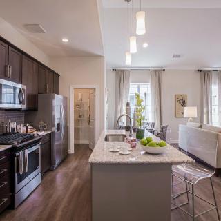 A modern kitchen with an open concept design featuring an island counter and stainless steel appliances.