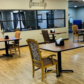 A spacious dining area designed for family gatherings, featuring empty tables and comfortable chairs.