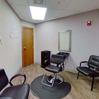 A cozy hair salon interior with a barber chair and waiting area.