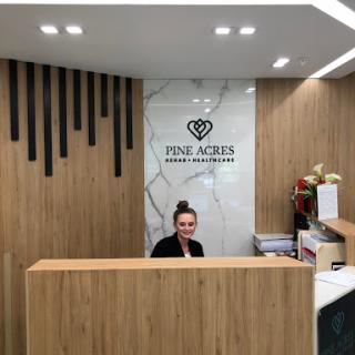 A reception area showcasing modern interior design with a wooden counter and elegant decor.