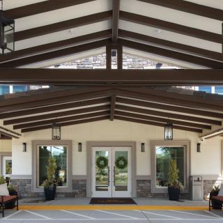 A symmetrical building entrance with a covered walkway and outdoor seating.