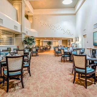 A spacious and elegantly decorated dining area with neatly arranged tables and chairs.