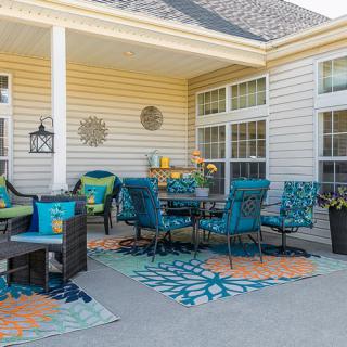 A cozy outdoor patio with vibrant furniture and decorative elements.