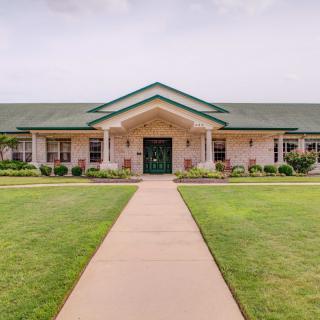 A single-story building with a green roof and well-maintained lawn.