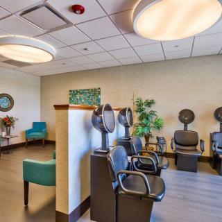 Modern salon interior with hair drying stations and a cozy waiting area.
