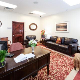 A welcoming office space featuring comfortable seating and an organized desk.