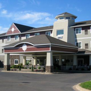 A modern hotel building with a welcoming entrance and clear blue skies.