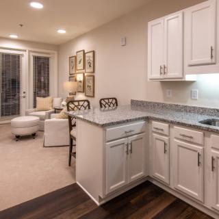 A modern open-concept kitchen and living area featuring white cabinets and tasteful decor.
