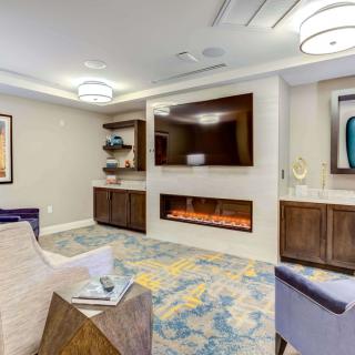 A modern living room with comfortable seating, a stylish fireplace, and contemporary artwork.