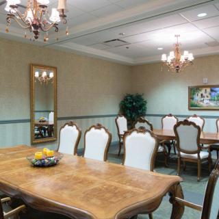 A formal dining room with elegant furniture and chandeliers.