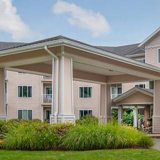 A large residential building with a covered entrance and well-maintained landscaping.