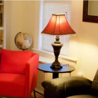 Cozy living room with a red chair, lamp, and globe.