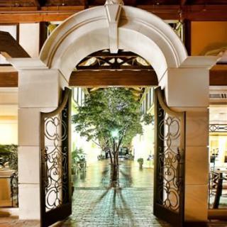 A beautifully lit archway leading to a tree-lined corridor.