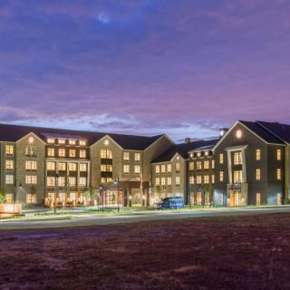A well-lit hotel building under a twilight sky.