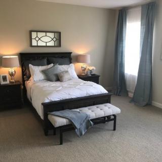 A well-furnished bedroom with a cozy bed, elegant decor, and soft lighting.