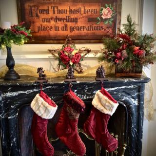 A beautifully decorated fireplace mantel with Christmas stockings and festive garlands.