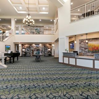 A spacious and elegant hotel lobby featuring a chandelier and reception desk.