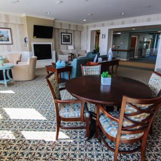 A well-lit living room with a round table, chairs, and modern decor.