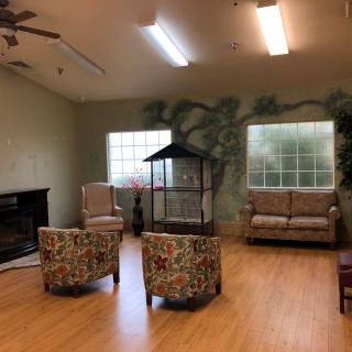 A cozy living room with a seating area, featuring a sofa, chairs, and a fireplace.