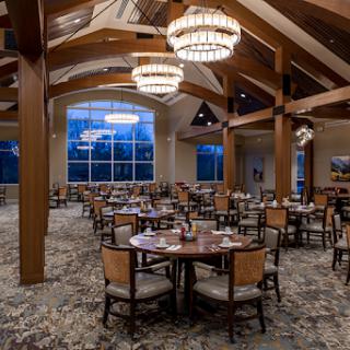 A spacious and elegantly designed dining area featuring wooden beams and stylish chandeliers.