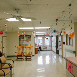 A bright and inviting waiting area in a healthcare facility, decorated with colorful hanging ornaments.
